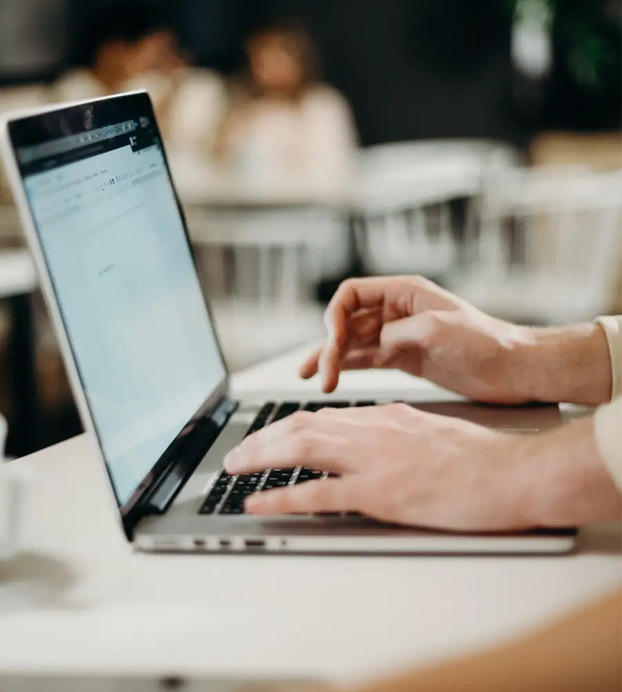 Human hands writing email on laptop